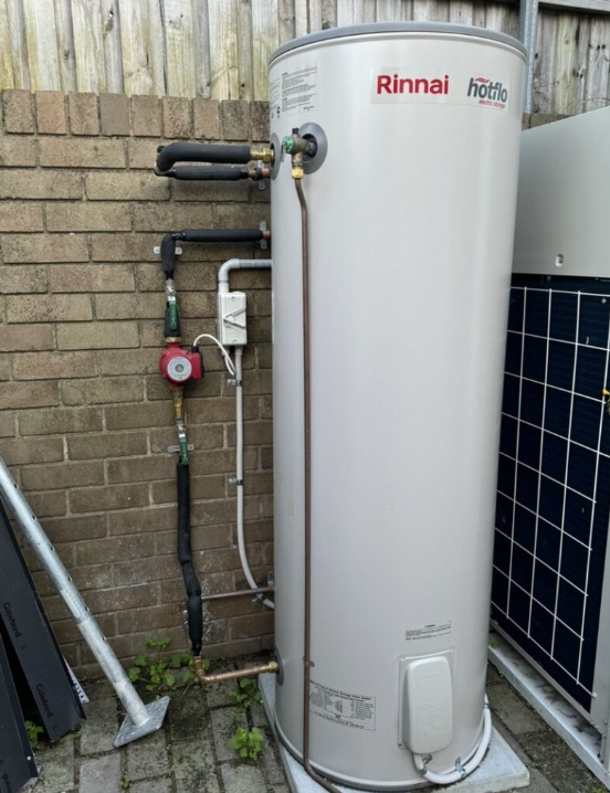 Plumber Melbourne inspecting a Rinnai hot water system with external pipework